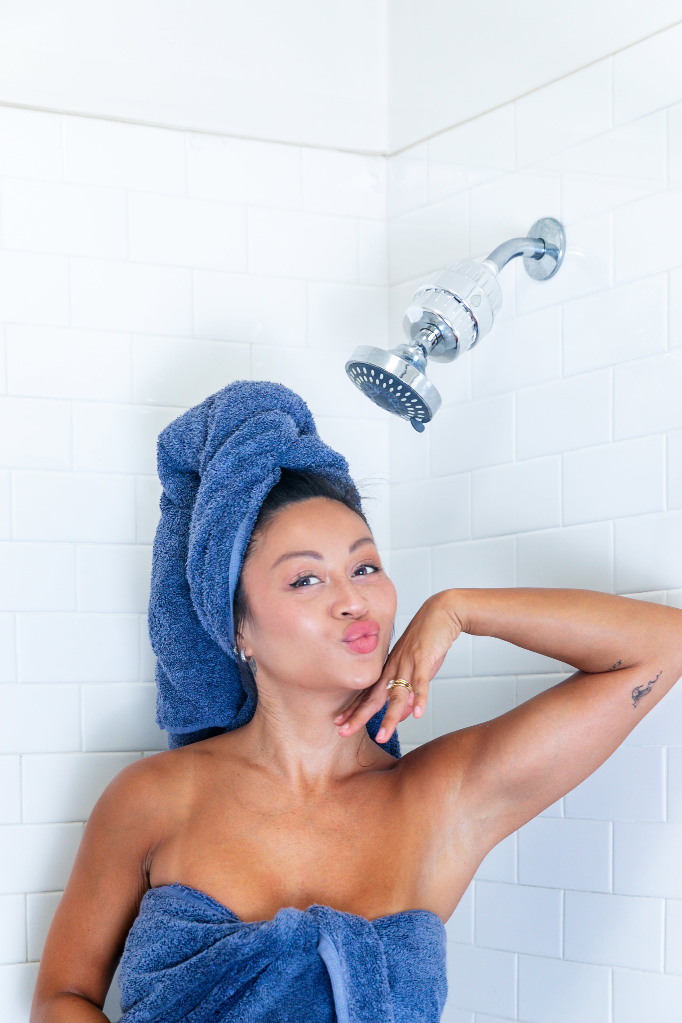 Woman after shower with GoodFor 8-Stage Shower Filter installed above
