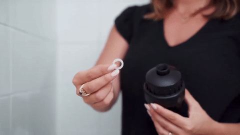 Placing the gasket inside the top opening of the shower filter