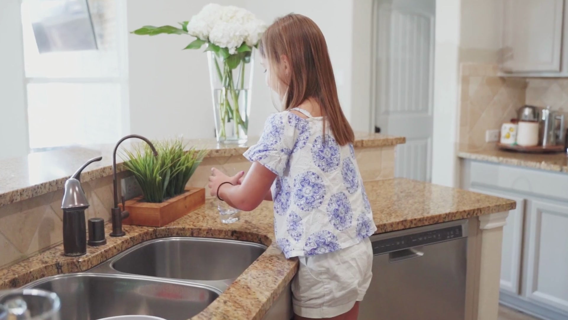 young girl drinking from reverse osmosis